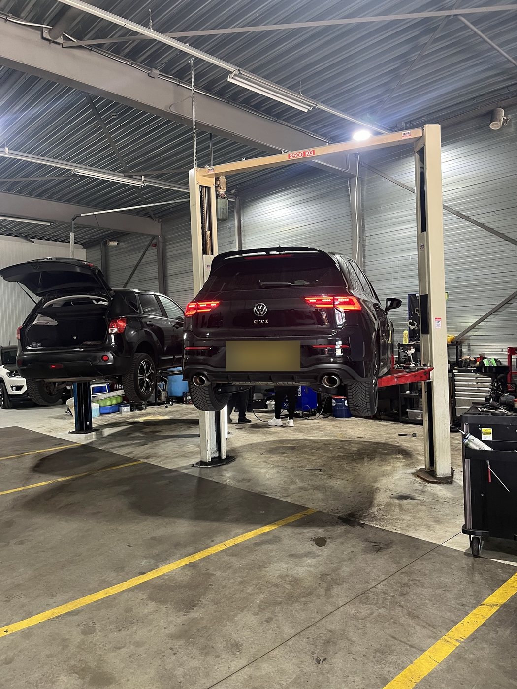 Zwarte Volkswagen Golf GTI op de tweekolomsbrug in de werkplaats